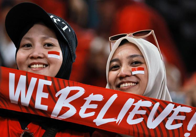 Fans hold up a banner in support of the Indonesia soccer team at King Abdullah Sports City Stadium in Jeddah on Oct. 8, 2025, ahead of the team’s match against Saudi Arabia during the fourth round of the men’s FIFA World Cup 2026 Asian qualifier.