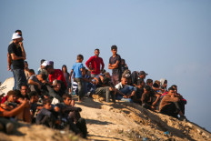 Palestinians look toward Gaza City from a hilltop in Nuseirat in the central Gaza Strip on October 10, 2025. Gaza's civil defense agency said on October 10 that Israeli forces have begun pulling back from parts of the territory, particularly in Gaza City and Khan Yunis. Israeli prime minister's office said that the government had “approved the framework“ of a hostage release deal with Hamas, as both sides edged closer to ending more than two years of hostilities in Gaza.