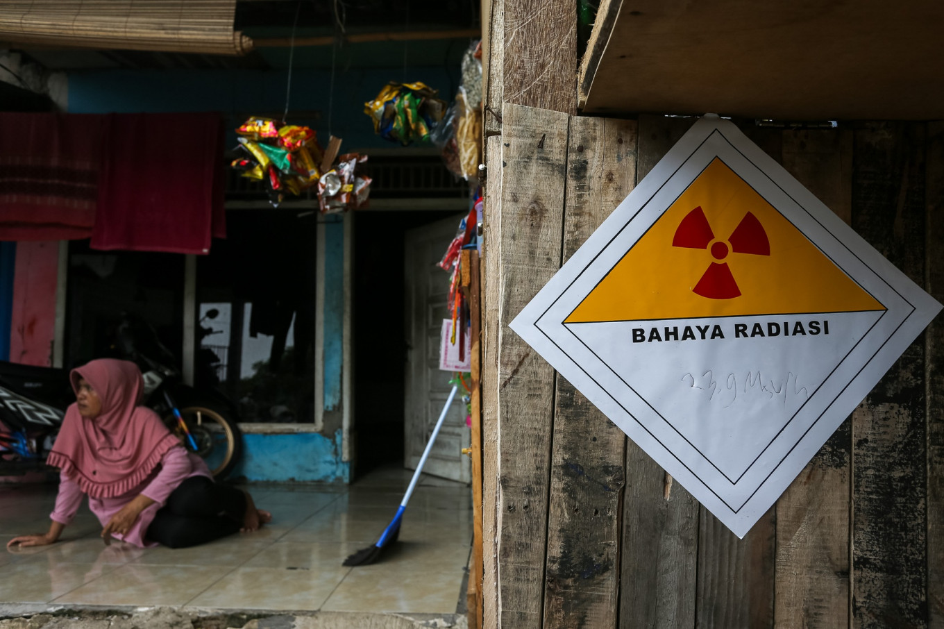A woman sits on Oct. 8 on the terrace of her house which is located near the Modern Cikande Industrial Estate (MCIE) in Serang, Banten, that has been contaminated by radioactive Cesium-137, which is believed to have come from imported scrap metal to be recycled by a local company.