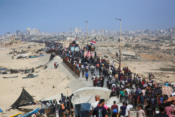 Palestinians make their way along Al-Rashid road toward Gaza City from Nuseirat in the central Gaza Strip on October 10, 2025. Israeli forces declared a ceasefire and withdrew from some positions in Gaza on October 10, as thousands of displaced Palestinians began to trek home and the families of October 7 hostages awaited news. Israeli prime minister's office said that the government had “approved the framework“ of a hostage release deal with Hamas, as both sides edged closer to ending more than two years of hostilities in Gaza.