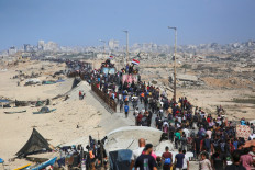 Palestinians make their way along Al-Rashid road toward Gaza City from Nuseirat in the central Gaza Strip on October 10, 2025. Israeli forces declared a ceasefire and withdrew from some positions in Gaza on October 10, as thousands of displaced Palestinians began to trek home and the families of October 7 hostages awaited news. 
