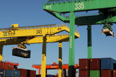 A gantry crane lifts a container at a port in Tianjin, China, on Febr. 8, 2025.