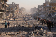 Peace, of a sort: Palestinians walk on Friday through a damaged neighborhood in the aftermath of an Israeli operation, after Israel's government ratified a ceasefire with Hamas, in Gaza City, Palestine.