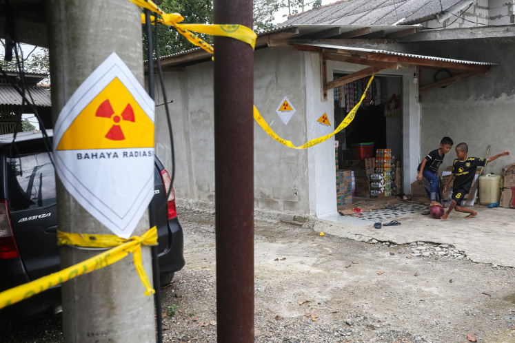 Dangerous playground: Two children play on Wednesday near the site where Cesium-137 (Cs-137) contamination was discovered in the Cikande Modern Industrial Estate in Serang regency, Banten. The Environment Ministry is preparing temporary relocation measures for residents living near the Cs-137 radiation point until the decontamination process is complete and the area is declared safe.