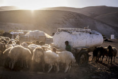 A young Palestinian Bedouin boy gives water to a flock of sheep by his family's water tank in Ras Ein al-Auja in the Jordan Valley in the Israeli occupied West Bank on Sept. 30, 2025. Since the start of the war in Gaza, deadly Israeli settler attacks on Palestinians in the West Bank have become commonplace. In recent months, settlers in the Jordan Valley took control of the Al-Auja spring by diverting its water from upstream, a representative of the community said.