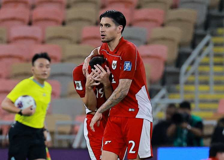 Indonesian defender Kevin Diks (right) embraces teammate Thom Haye (center) after the 2026 World Cup Asian fourth round qualifier match between Indonesia and Iraq at the King Abdullah Stadium in Jeddah, Saudi Arabia on Oct. 11, 2025.