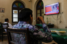 People watch a televised press briefing by Ahmed Sharif Chaudhry, director general of the Inter-Services Public Relations wing of the Pakistan Armed Forces, in Karachi, Pakistan, on Oct. 10, 2025.