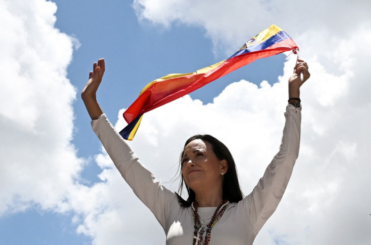 Venezuelan opposition leader Maria Corina Machado waves a Venezuelan flag during a rally in Caracas on Aug. 28, 2024. Machado wins the 2025 Nobel Peace Prize, the Norwegian Nobel Committee announced on Oct. 10, 2025.