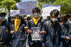 A demonstrator holds on Aug. 30 a portrait of Affan Kurniawan, an ojol (online motorcycle transportation) driver who was run over by a police Mobile Brigade (Brimob) armored vehicle, during a protest in front of the East Java Police headquarters in Surabaya, East Java. Indonesia was rocked by protests in major cities on Aug. 29 after footage spread of Affan being run over by a police tactical vehicle in earlier rallies against low wages and financial perks for lawmakers.