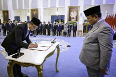 Dony Oskaria (left) signs an official decree as President Prabowo Subianto inaugurates the head and deputy heads of the State-Owned Enterprises (SOEs) Regulatory Agency (BP BUMN) at the State Palace in Jakarta on Oct. 8, 2025. (BPMI Setpres/Laily Rachev)