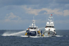 Sea clash: A China Coast Guard ship (right) deploys a water cannon on Sunday, October 12,  as a Philippine Bureau of Fisheries vessel (left) sails during an incident off Thitu Island in disputed South China Sea waters.