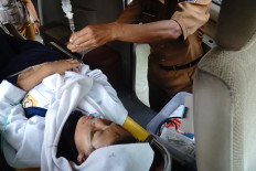 Safety alert: A student affected by food poisoning from the free meals program at SMPN 1 Boyolangu state junior high school gets an intravenous infusion on Monday before taken to Campurdarat dr. Karneni Regional General Hospital in Tulungagung, East Java. 