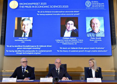 John Hassler, Chair of the Committee for the Prize in Economic Science in Memory of Alfred Nobel, the Secretary General of the Royal Swedish Academy of Sciences Hans Ellegren and Kerstin Enflo, member of the Committee for the Prize in Economic Sciences in Memory of Alfred Nobel (left to right) sit in front of a screen displaying the portraits of the 2025 prize winners (left to right) Joel Mokyr, Philippe Aghion and Peter Howitt, as they addresses journalists during the announcement of the winner of the 2025 Nobel Prize in Economics, the Sveriges Riksbank Prize in Economic Sciences in Memory of Alfred Nobel, at the Royal Swedish Academy of Sciences in Stockholm, Sweden, on October 13, 2025. The Nobel prize in economics was awarded to American-Israeli Joel Mokyr, France's Philippe Aghion and Canada's Peter Howitt for work on technology's impact on sustained economic growth. 