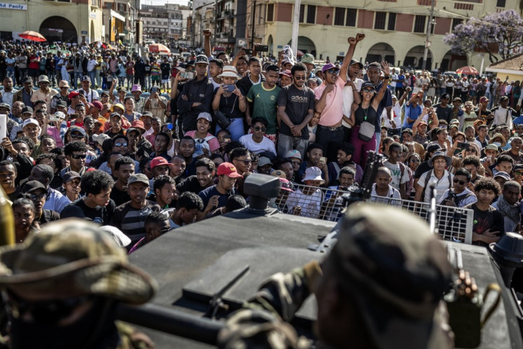 Residents and protesters react to the address of members of Madagascar's Army CAPSAT unit at a civil society rally calling for President Andry Rajoelina's resignation, before heading to the Presidential Palace in Antananarivo, October 14, 2025. An elite Madagascar military unit told AFP on October 14, 2025 it had taken power in the country after the national assembly voted to impeach President Andry Rajoelina for desertion of duty. 