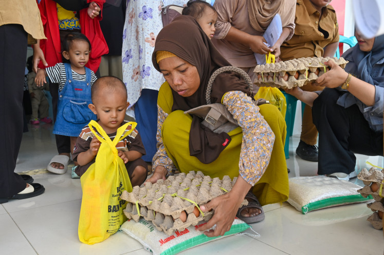 A woman collects a tray of eggs on Oct. 15, 2025, during an anti-stunting food distribution event organized by the municipal administration of Palu, Central Sulawesi.