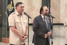 Defense Minister Sjafrie Sjamsoeddin listens as NasDem chairman Surya Paloh speaks to the media after their meeting on Wednesday.