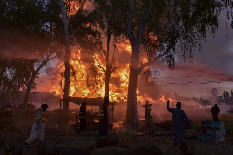 Firefighters try to douse a fire at a oil tanker terminal in Nowshera on April 30, 2022. 