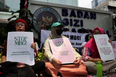 Food poisoning concern: Protesters hold placards outside the National Nutrition Agency building during a rally on Oct. 15, 2025, demanding an end to the government’s free nutritious meals (MBG) program, following food poisoning in Jakarta schools. Food poisoning cases related to the MBG program have continued despite government claims to be implementing more safeguards.