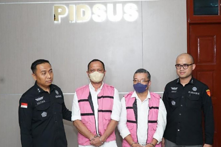 Land schemers: Two North Sumatra Prosecutor’s Office’s officers escort two suspects ('center left' and 'center right') after being questioned, before being returned to the detention center. The office named two former National Land Agency (BPN) officials as suspects for allegedly transferring about 8,000 hectares of land owned by state-owned plantations PT Perkebunan Nusantara (PTPN) I to a private developer.