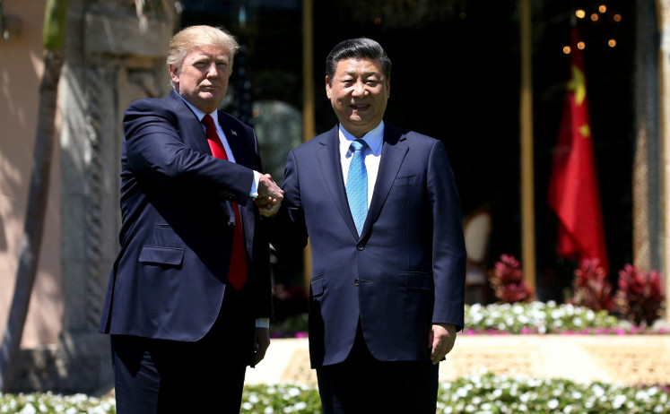 United States President Donald Trump (left) and China's President Xi Jinping shake hands while walking at Mar-a-Lago estate after a bilateral meeting in Palm Beach, Florida, the US, on April 7, 2017.