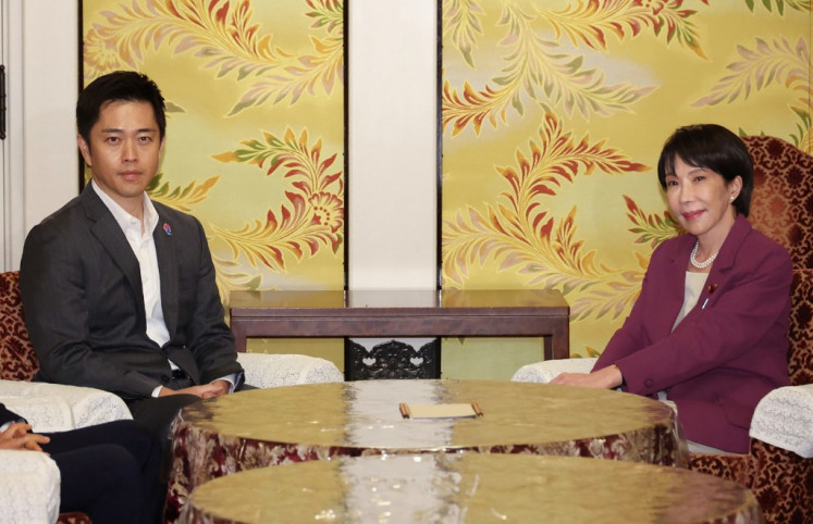 Ruling Liberal Democratic Party (LDP) president Sanae Takaichi (right) and head of the major opposition Japan Innovation Party Hirofumi Yoshimura attending a meeting at the Diet in Tokyo on Oct. 15, 2025. Japan's top three opposition leaders met on Oct. 15 to seek a unified candidate for prime minister in their bid to oust the ruling party from power, only to find there were still “gaps“ between them.