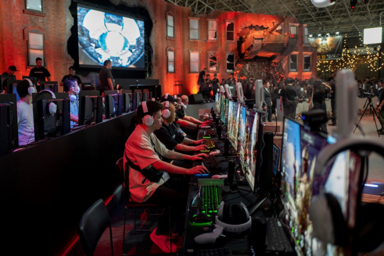 Visitors play video games at a booth during the preview day for the annual Tokyo Game Show at Makuhari Messe in Chiba City, Chiba Prefecture, Japan on Sept. 25, 2025.