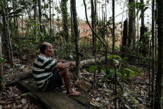 Ngigoro, 62, an elder of the Hongana Manyawa indigenous tribe who left the forest and now lives in a village with his mother, watches a nickel mining site from the edge of the forest on April 16 in East Halmahera, North Maluku.