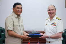 Defense Minister Sjafrie Sjamsoeddin ('left') presents a model of an Indonesian Navy patrol boat to Australian Chief of Defense Force Adm. David Johnston ('right') during a courtesy call at the Defense Ministry in Jakarta on Friday. Both countries agreed to increase people-to-people contact among military personnel, strengthen institutional relations between defense institutions and widen cooperation in training, education and cybersecurity.