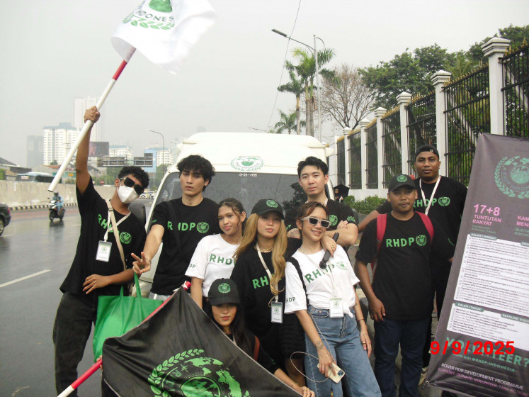 Karina (center), holding the Rover Hub Development Program (RHDP) flag, and her team pose by their mobile aid post.