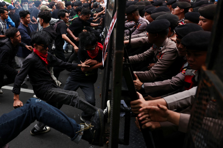 Demonstrators try to break the police barricade during a protest on the first anniversary of Indonesian President Prabowo Subianto's administration, criticizing government policies, including the free meals program, in Jakarta, October 20, 2025.