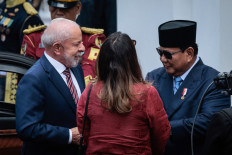 Brazil's President Luiz Inacio Lula da Silva (left) is welcomed by President Prabowo Subianto (right) on Thursday upon his arrival at the presidential palace in Jakarta. 