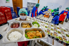 A nutritionist shows a meal package to be distributed under the free nutritious meal program at the Tanjunganom kitchen in Nganjuk, East Java, on Oct. 20, 2025.