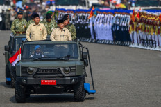 President Prabowo Subianto (third right), Defense Minister Sjafrie Sjamsoeddin (second left), Indonesian Military (TNI) commander Gen. Agus Subiyanto (second right), TNI deputy commander Gen. Tandyo Budi Revita (third left) and Indonesian Air Force chief of staff Air Chief Marshal Tonny Harjono (left) ride in tactical vehicles on Oct. 5 while inspecting troops during the TNI's 80th anniversary ceremony at the National Monument (Monas) compound in Jakarta.
