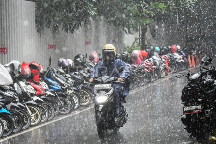 A motorcycle rider braves the rain in the Senopati area, South Jakarta on March 14, 2025. 