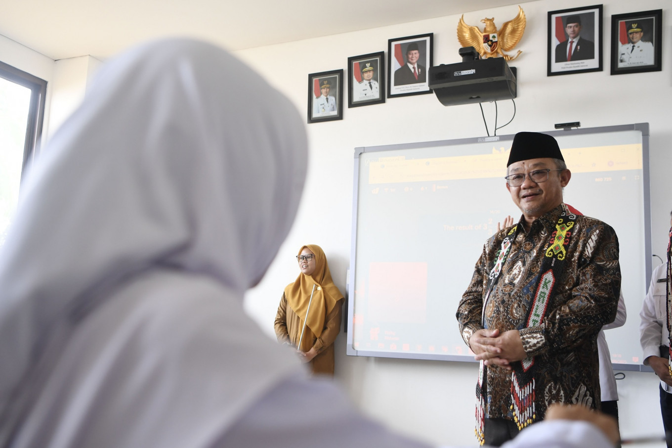Elementary and Secondary Education Minister Abdul Mu'ti (right) talks with a student on the sidelines of the inauguration of an integrated school on Sept. 30 in Samarinda, East Kalimantan. The international-standard school integrates schools of three levels of education, namely SDN 28 state elementary school, SMPN 16 state junior high school and SMA Prestasi senior high school.