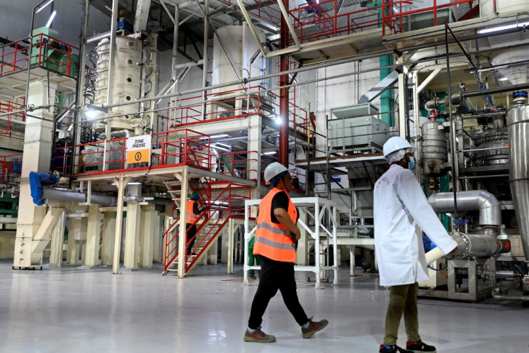 Workers walk inside the Chocolate and Cocoa butter factory in Divo on Oct. 20, 2025.