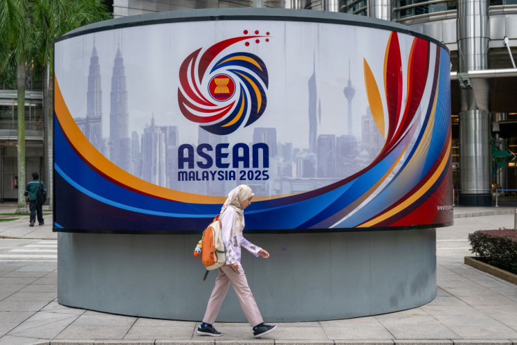 Roundup ready: A woman walks on Oct. 23, 2025 past a promotional display for ASEAN Malaysia 2025 in front of the Petronas Twin Towers in Kuala Lumpur, which is hosting the regional grouping’s 47th annual summit from Oct. 26 to 28.