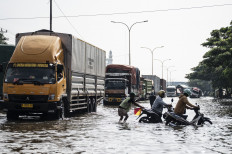 Unstoppable tide: Residents push their motorbikes on Friday through floodwaters that inundated Jl. Kaligawe Raya in Semarang, Central Java, a section of the Java Northern Coast (Pantura) Highway, located between Semarang and Surabaya, East Java.