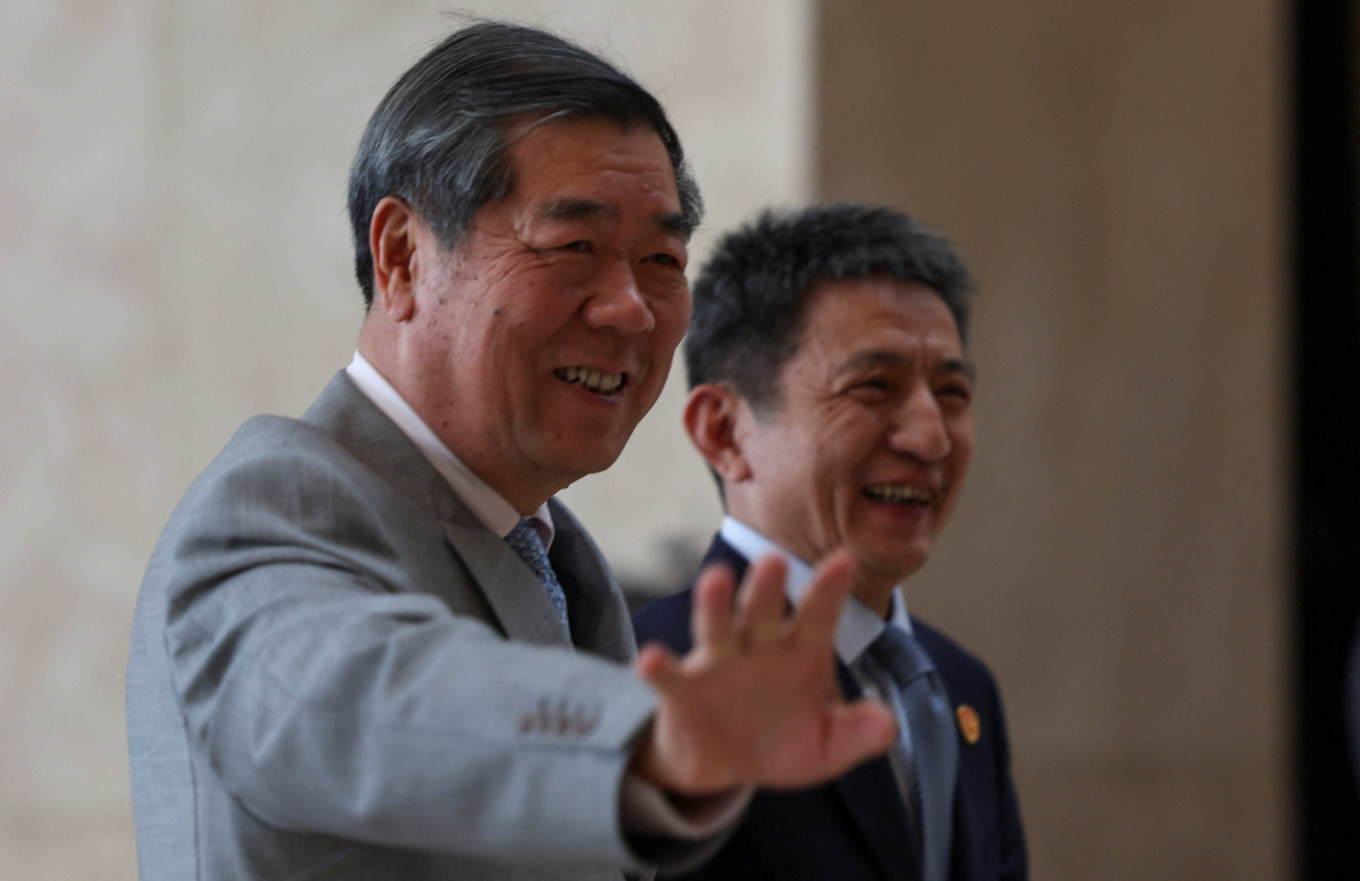 Chinese Vice Premier He Lifeng waves to photographers with China's top trade negotiator Li Chenggang during a break of trade talks between the United States and China, in Kuala Lumpur on Oct. 25, 2025.