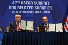 US President Donald Trump (left) and Malaysia's Prime Minister Anwar Ibrahim (right) hold up signed documents on a critical minerals deal during a bilateral meeting on the sidelines of the 47th Association of Southeast Asian Nations (ASEAN) Summit in Kuala Lumpur on October 26, 2025. 