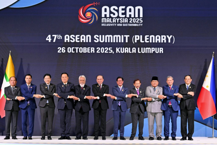Malaysia's Prime Minister Anwar Ibrahim (center) holds hands with (from left to right) Myanmar's Permanent Secretary of the Ministry of Foreign Affairs Hau Khan Sum, Vietnam's Deputy Minister of Foreign Affairs Dang Hoang Giang, Singapore's Prime Minister Lawrence Wong, Thailand's Prime Minister Anutin Charnvirakul, East Timor's Prime Minister Xanana Gusmao, Philippines' President Ferdinand Marcos Jr, Sultan of Brunei Hassanal Bolkiah, Indonesia's President Prabowo Subianto, Cambodia's Prime Minister Hun Manet and Laos' Prime Minister Sonexay Siphandone during a group photo as they attend the plenary session of the 47th Association of Southeast Asian Nations (ASEAN) Summit in Kuala Lumpur on October 26, 2025. 