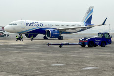Ground staff walk past an Indigo airlines aircraft taxiing in the apron at the Netaji Subhash Chandra Bose International airport in Kolkata on February 1, 2024. India and China resume direct flights on October 26 after a five-year suspension, a move important both for trade and a symbolic step as Asia's giants cautiously rebuild relations.