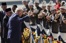 US President Donald Trump (center) joins performers for a dance during the welcome ceremony next to Malaysia's Prime Minister Anwar Ibrahim (left) as he arrives on Air Force One at Kuala Lumpur International Airport in Sepang on October 26, 2025.