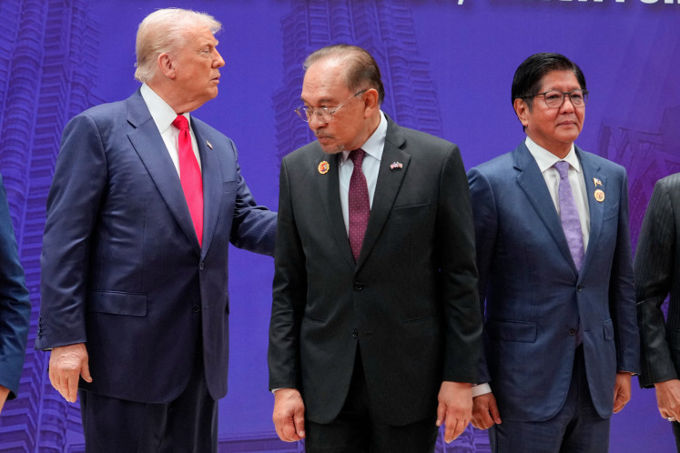US President Donald Trump looks at Philippine President Ferdinand Marcos Jr., next to Malaysian Prime Minister Anwar Ibrahim when posing for a family photo with leaders at the ASEAN Summit in Kuala Lumpur on Oct. 26, 2025.