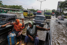 Resilience in action: Residents travel in a truck on Monday, Oct. 27, through floodwater on Jl. Kaligawe Raya in Semarang, Central Java. According to local authorities, floodwaters have inundated Jl. Kaligawe Raya decreased to around 20-50 centimeters on Monday from 70 cm on Friday.