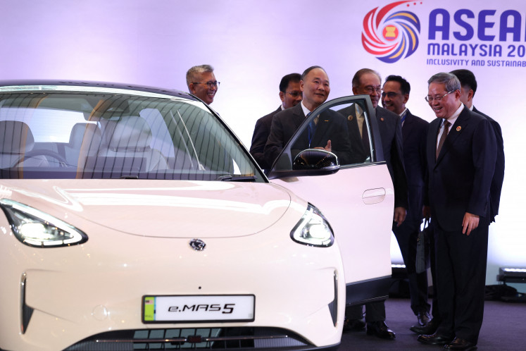 Chinese Premier Li Qiang reacts as he, along with Malaysian Prime Minister Anwar Ibrahim, inspects a car produced by Malaysia's national automaker, Proton, in which China's Zhejiang Geely Holding Group holds a 49.9% stake, ahead of the signing ceremony for the ASEAN–China Free Trade Area 3.0 Upgrade and the 28th ASEAN–China Summit, held as part of the 47th ASEAN Summit in Kuala Lumpur on  Oct. 28, 2025.