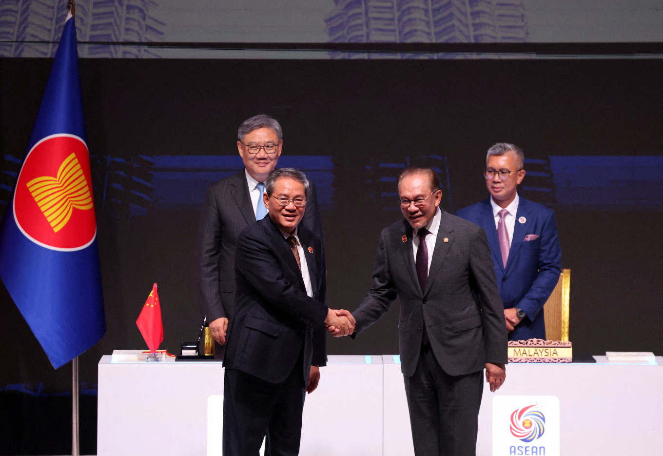 ASEAN chairman and Malaysia's Prime Minister Anwar Ibrahim and Chinese Premier Li Qiang shake hands after witnessing the signing of the ASEAN-China Free Trade Area 3.0 Upgrade signed by Malaysia Trade Minister and ASEAN Economic Ministers Chairman Tengku Zafrul Aziz and Chinese Commerce Minister Wang Wentao ahead of the 28th ASEAN–China Summit on Oct. 28, held as part of the 47th ASEAN Summit in Kuala Lumpur.