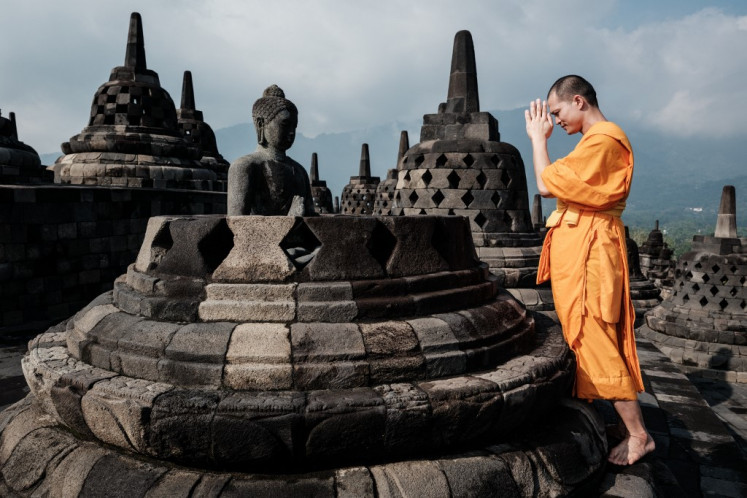 Prayer of light: A Buddhist monk prays on May 10 before a statue inside a stupa at Borobudur Temple, the world’s largest Buddhist monument and a UNESCO World Heritage Site, in Magelang, Central Java, ahead of Waisak.