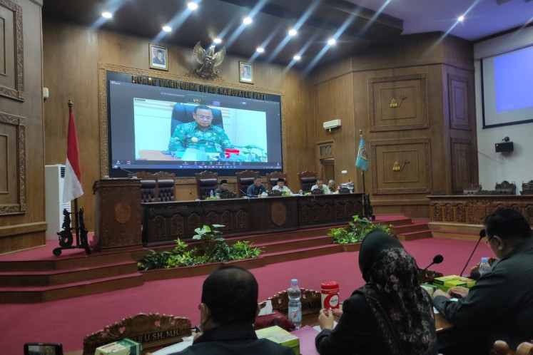 Pati Regent Sudewo is seen on a screen behind the Pati Regency Legislative Council (DPRD) speakers during a plenary session on Friday, to impeach him in Pati, Central Java. Sudewo survived the impeachment, with only the Indonesian Democratic Party of Struggle (PDI-P) agreeing to the motion.