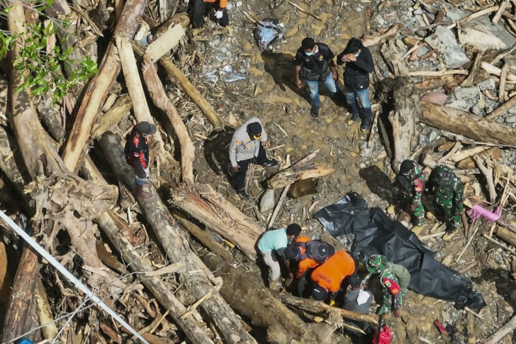 This handout photo taken and released on May 19, 2025 by the National Search and Rescue Agency (BASARNAS) shows rescuers recovering bodies after hours of heavy rain triggered flooding and a landslide near a gold mine in a remote area near Manokwari, West Papua.